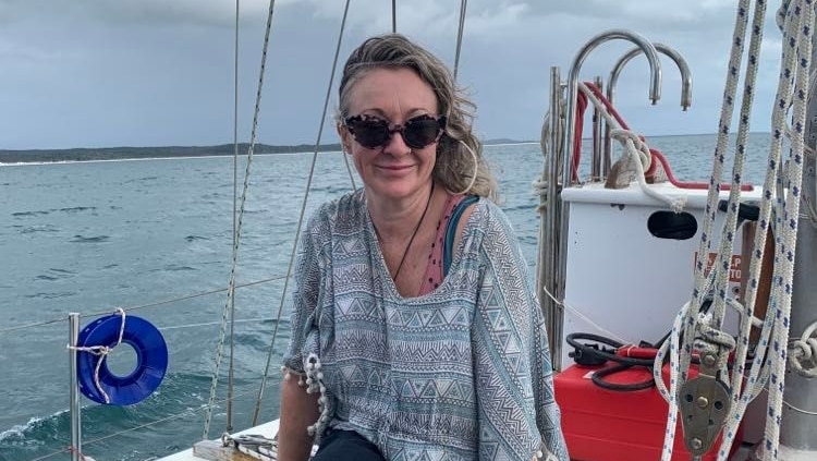 Michelle Answerth wearing sunglasses and smiling while sitting near the front of a boat.