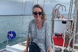 Michelle Answerth wearing sunglasses and smiling while sitting near the front of a boat.