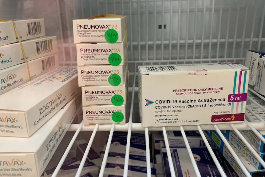 Boxes of flu vaccine sit in a fridge next to a box of AstraZeneca vaccine
