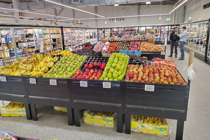 A grocery store with fully stocked fresh fruit and vegetables