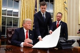 White House Staff Secretary Rob Porter hands President Donald Trump a confirmation order.