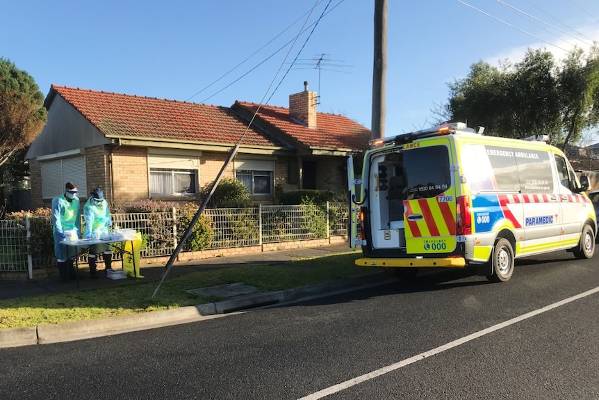 An ambulance and a makeshift coronavirus testing station on a residential street.