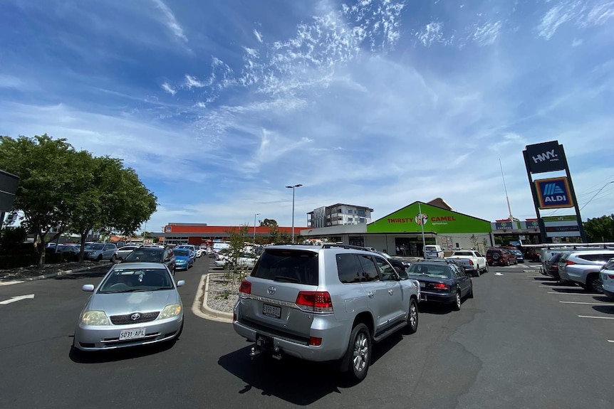 Cars lined up through a carpark to a bottleshop