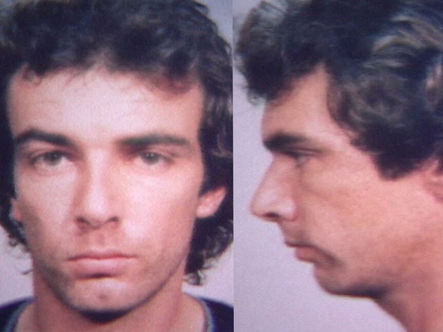 Mugshot of a young man with brown curly hair.