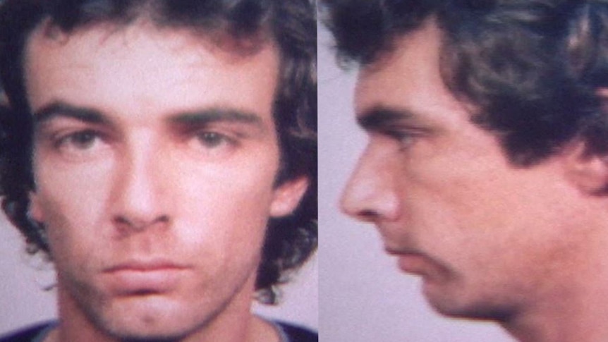 Mugshot of a young man with brown curly hair.