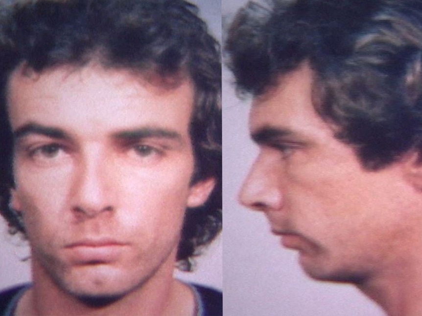 Mugshot of a young man with brown curly hair.