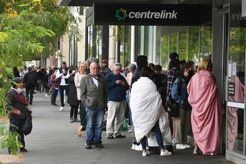 People queue outside a Centrelink in Melbourne on March 23