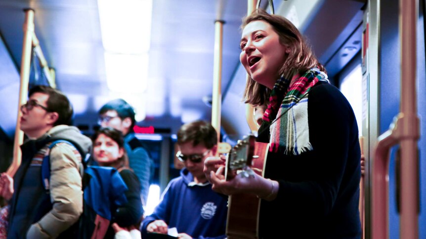 Delia Obst performs on an Adelaide tram.