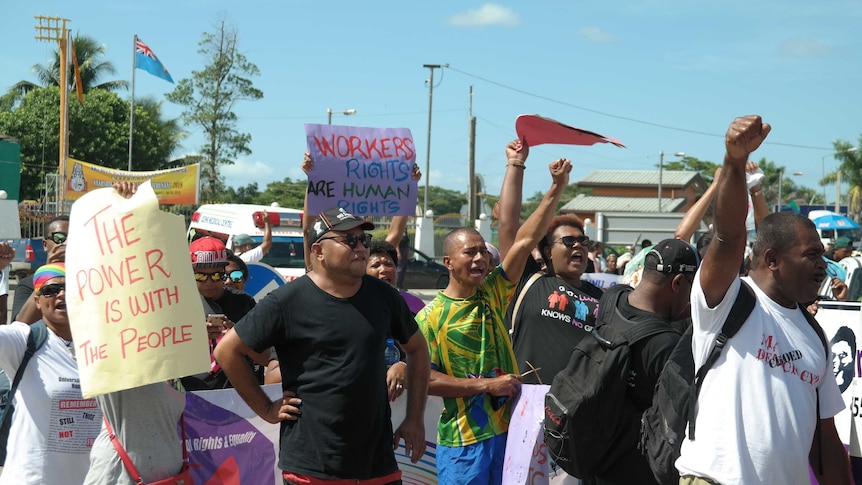 People chant with their fists in the air at a rally in Nadi, Fiji.