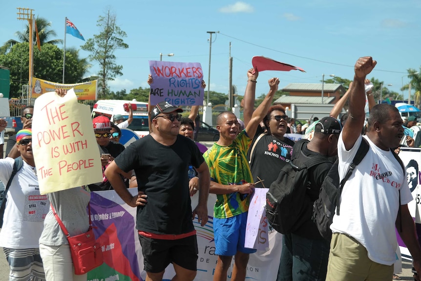 People chant with their fists in the air at a rally in Nadi, Fiji.