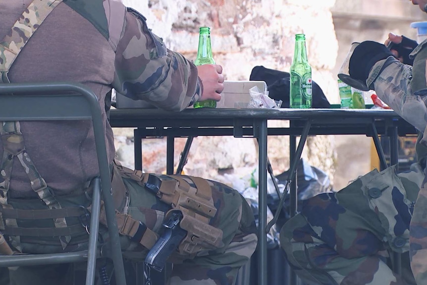 Legionnaires sit down and relax while enjoying a cold beer.