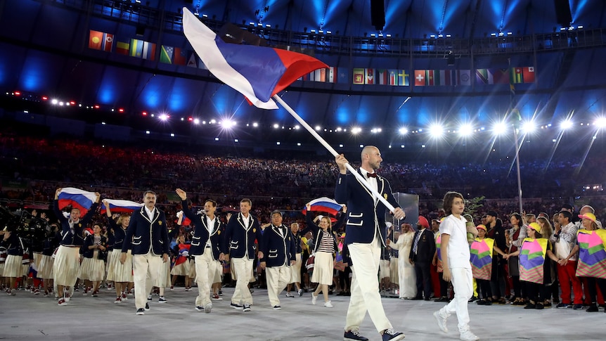 Sergei Tetiukhin carries a large Russian flag as he leads his team into the stadium at the 2016 Rio Olympics opening ceremony.