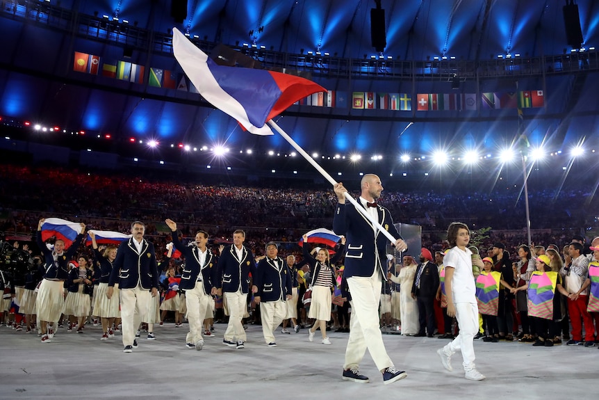 Sergei Tetiukhin carries a large Russian flag as he leads his team into the stadium at the 2016 Rio Olympics opening ceremony.