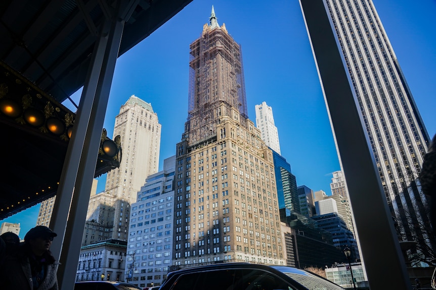 A skyscraper apartment complext in downtown Manhattan is shown rising into a clear sky.