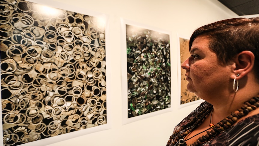 Profile of Bendigo Aboriginal feminist artist Tashara Roberts looking at her artwork.