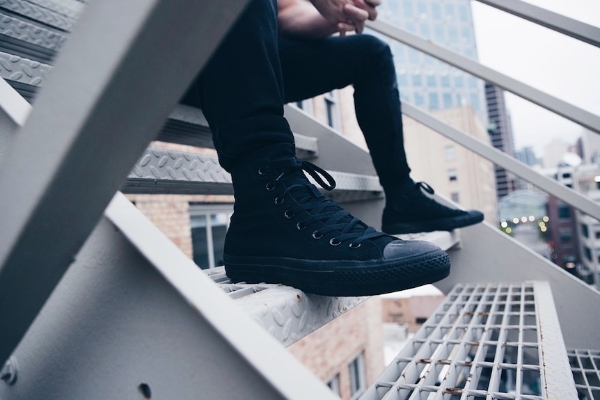 Man sitting on a stairway in a city.