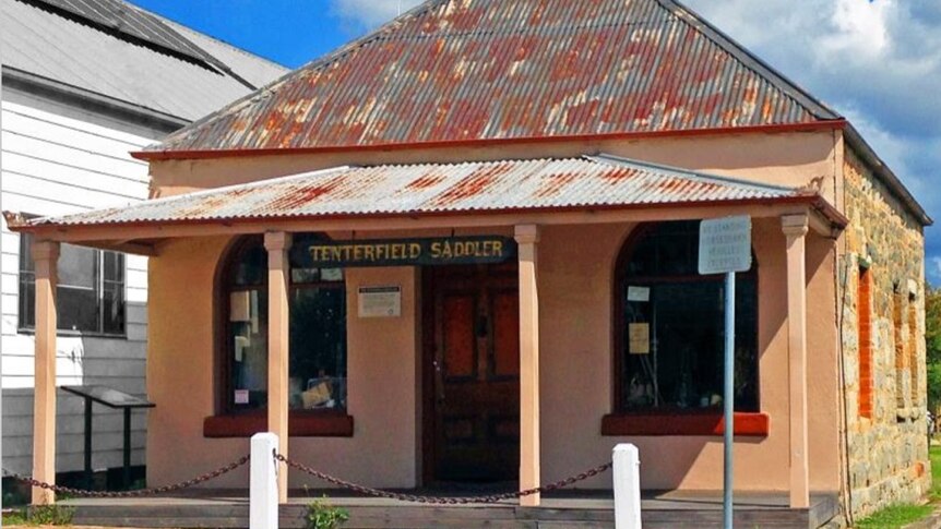 A clay coloured hertiage building with the sign Tenterfield Saddler above the balcony.