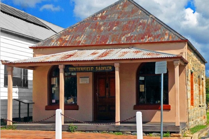 A clay coloured hertiage building with the sign Tenterfield Saddler above the balcony.