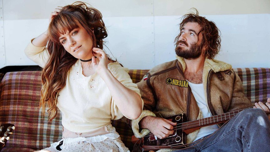 Angus & Julia Stone sitting on a couch