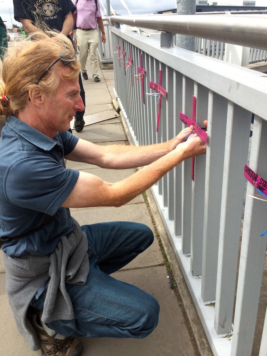 Brian Carey places cross on bridge over River Clyde
