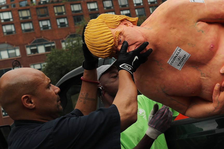 New York officials remove a statue of a naked Donald Trump