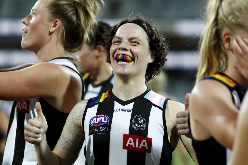 Ebony O'Dea of Collingwood gives the thumbs up to the camera, smiling with a rainbow mouth guard