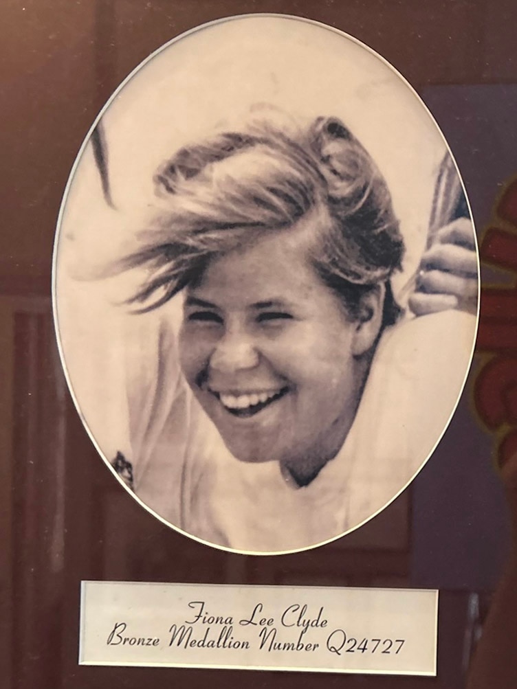Una fotografía en blanco de una mujer joven sonriente con cabello corto y claro.