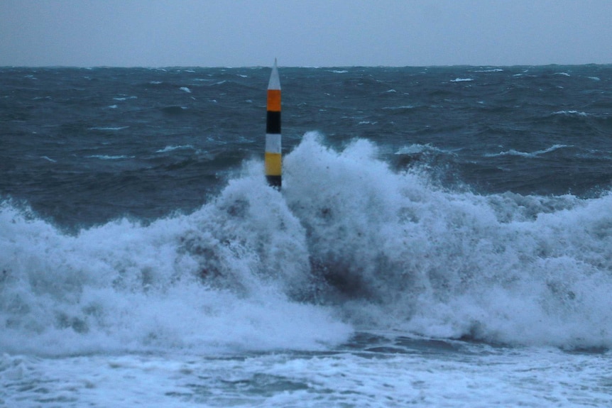 A big wave hits the pylon at Cottesloe Beach.