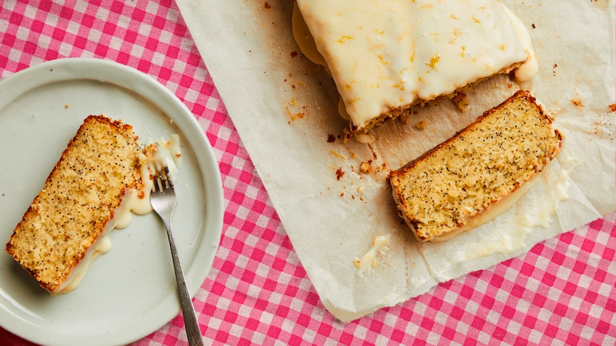 A lemon and poppyseed cake, served on a picnic blanket. 