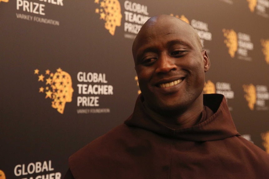 Kenyan teacher Peter Tabichi smiles while speaking to journalists.