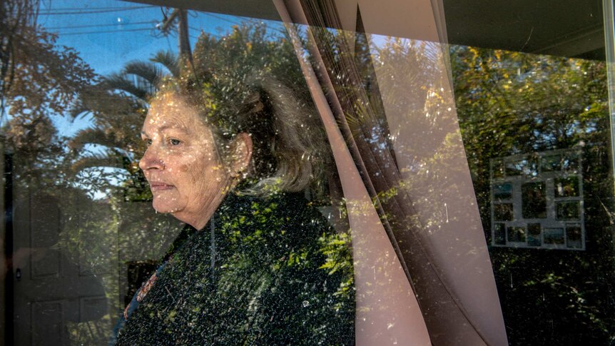 Kim Forrest is seen sitting at home by the window after being sued by A publicly listed debt collection company.