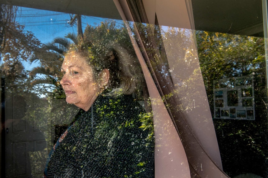 Kim Forrest is seen sitting at home by the window after being sued by A publicly listed debt collection company.