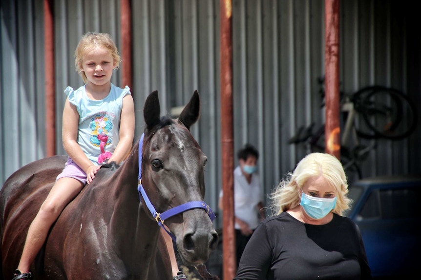 Melinda Samways and her daughter Holly riding a horse.