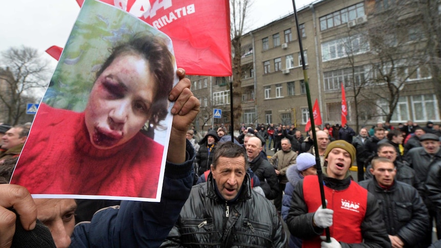 Protesters hold photos of Tetyana Chornovil during a demonstration at the Internal Affairs Ministry.