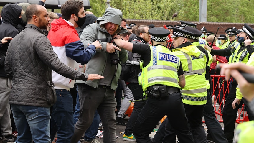 Police hold back protesters Old Trafford