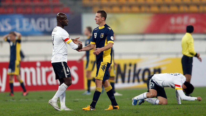 Well done ... Mitchell Duke (R) of the Mariners shakes hands with Jonas Salley of Guizhou