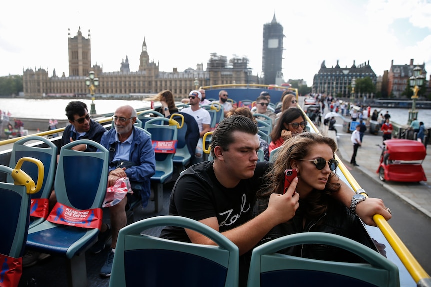 Tourists take pictures as they cross Westminster Bridge