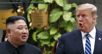 Kim Jong-un walks to the right of Donald Trump as they stroll through a hotel garden