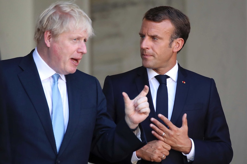 French President Emmanuel Macron and Britain's Prime Minister Boris Johnson gesture