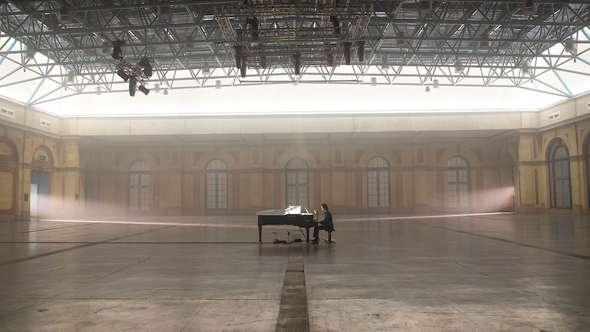 Nick Cave plays piano in the middle of a completely empty Alexandra Hall