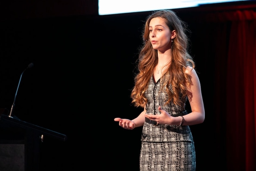 A woman standing on stage talking