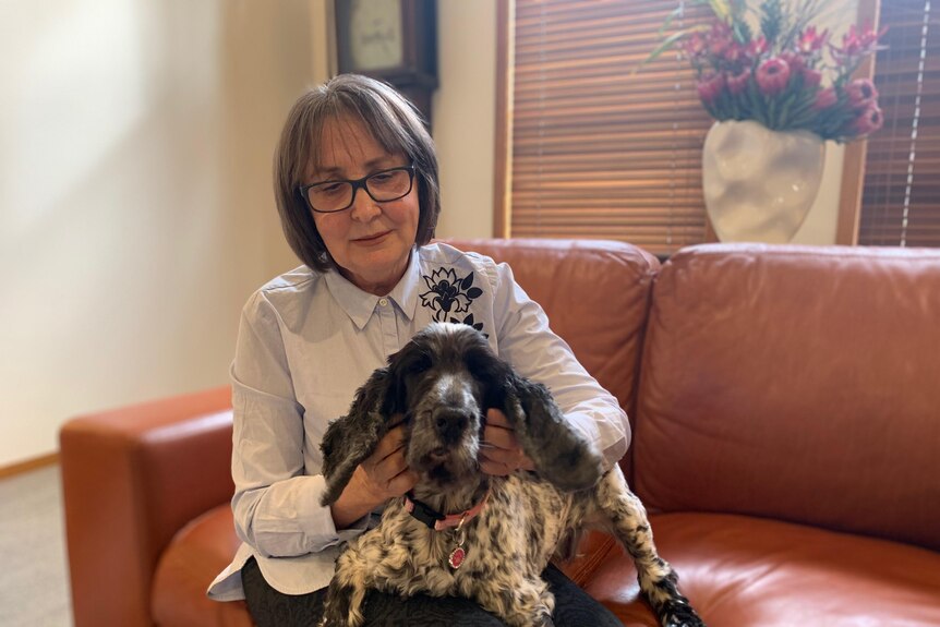 Doris Rosenkranz with her dog sitting on her lap.
