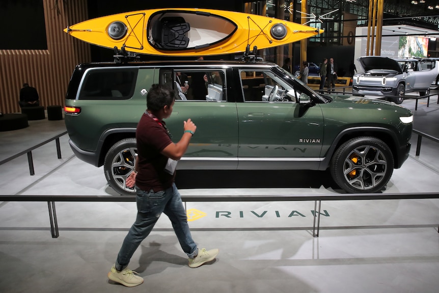 A green SUV on display with a yellow kayak on the roof.