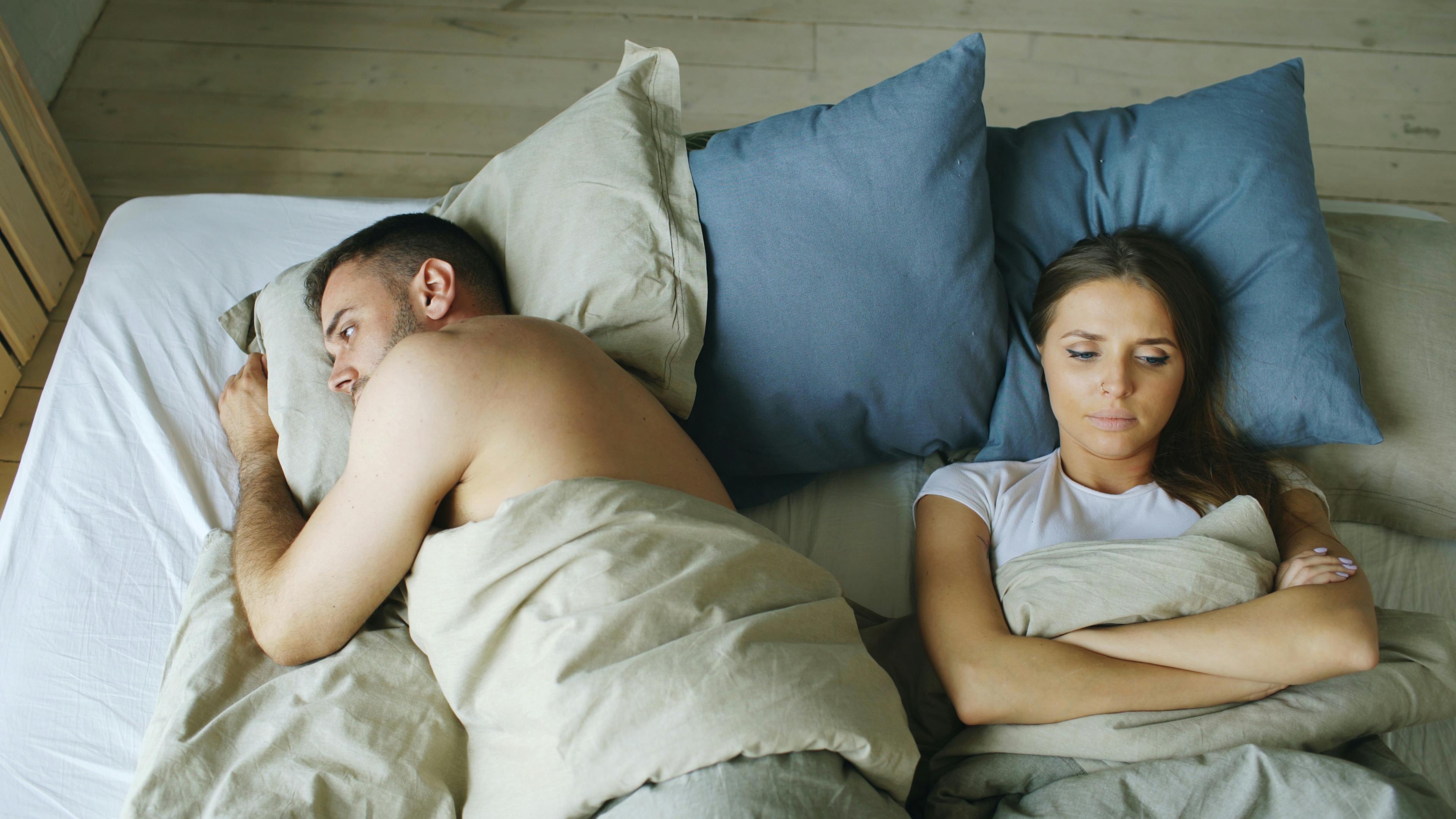 couple in bed turned away from each other
