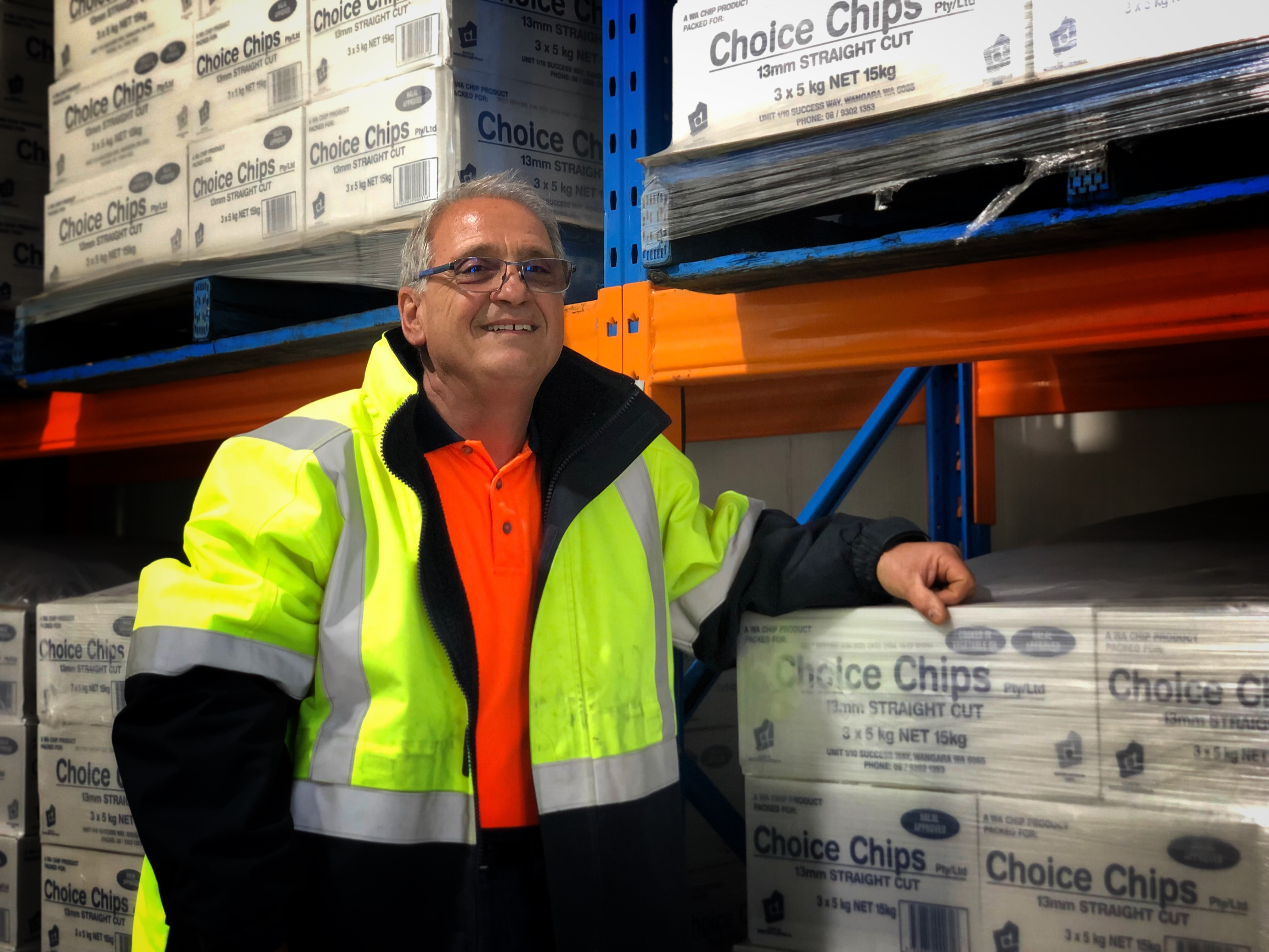 A man in a high-viz suit looks at the camera