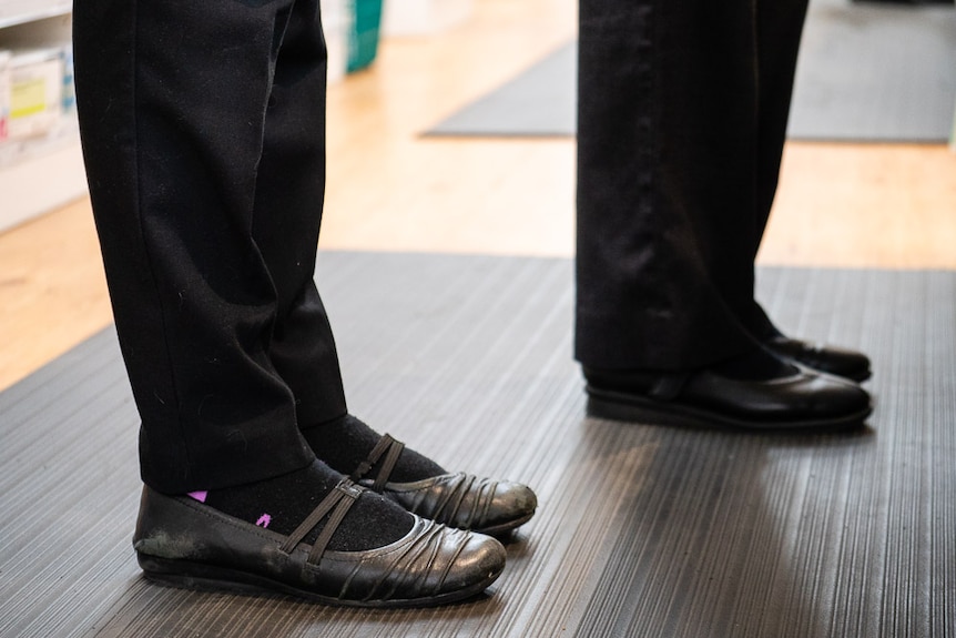 Two pairs of feet standing on an anti-fatigue mat to depict foot tips for people standing all day.