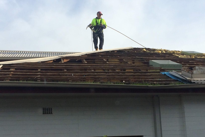 Repair work begins on a damaged roof in Sandy Bay