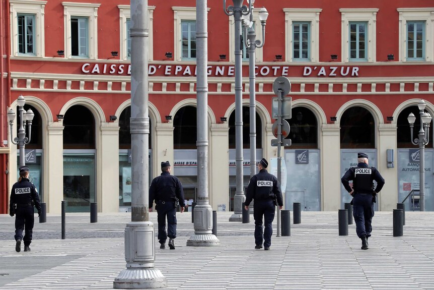 Four police patrol an empty public square in France