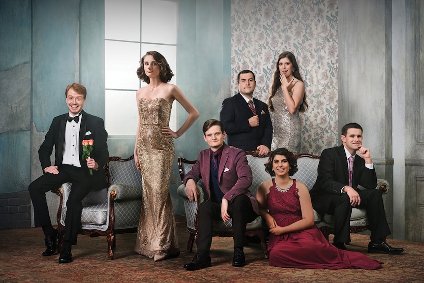 Staged shot of seven cast members of Love on the Spectrum, dressed in glamorous formal attire in an art deco styled room.