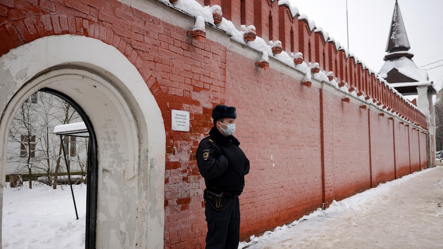 A police officer stands guard at the entrance of the Orthodox convent school after the bombing, December 13, 2021.